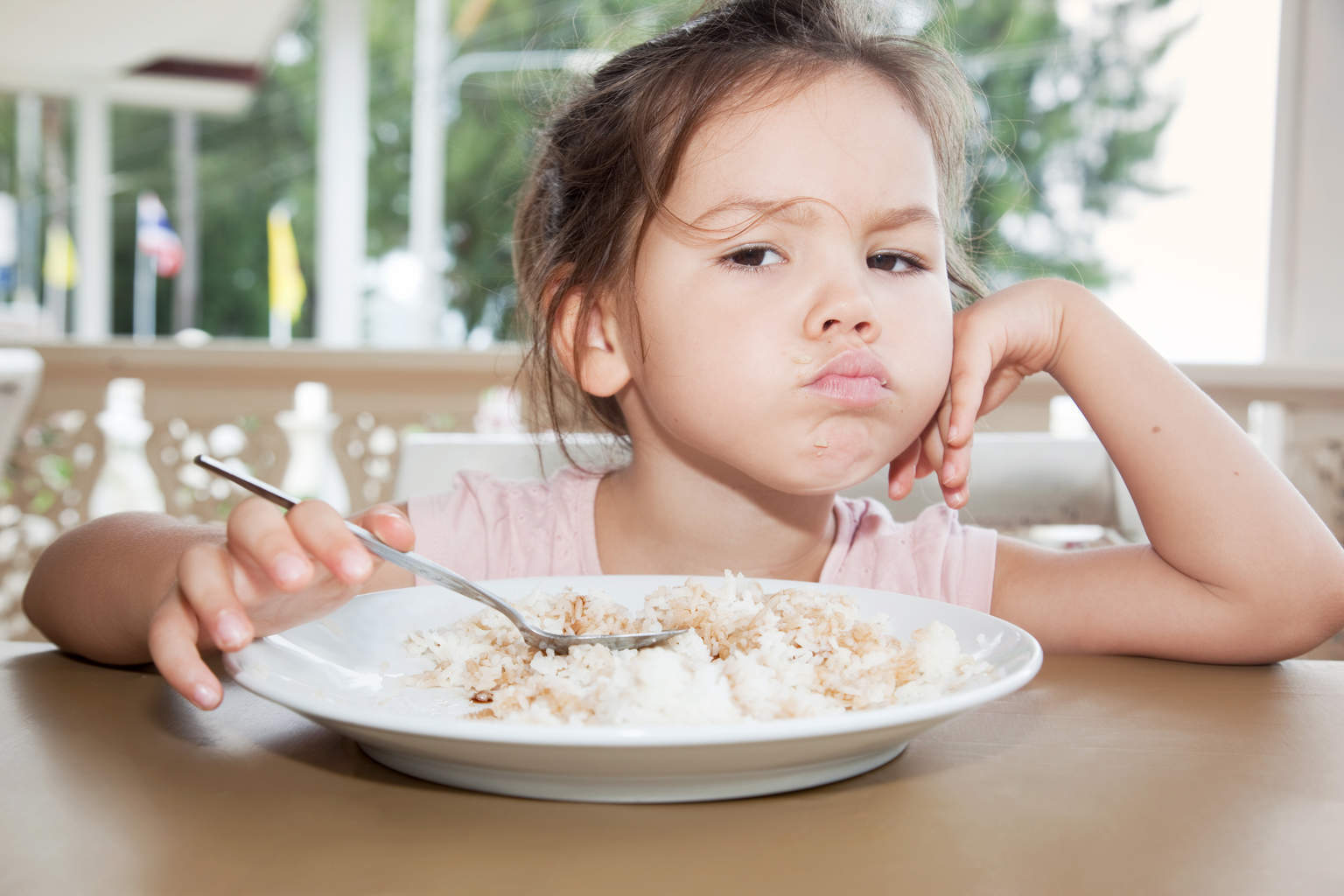 Не вкусно. Ребенок ест кашу. Девочка кушает. Девочка за столом. Девочка завтракает.