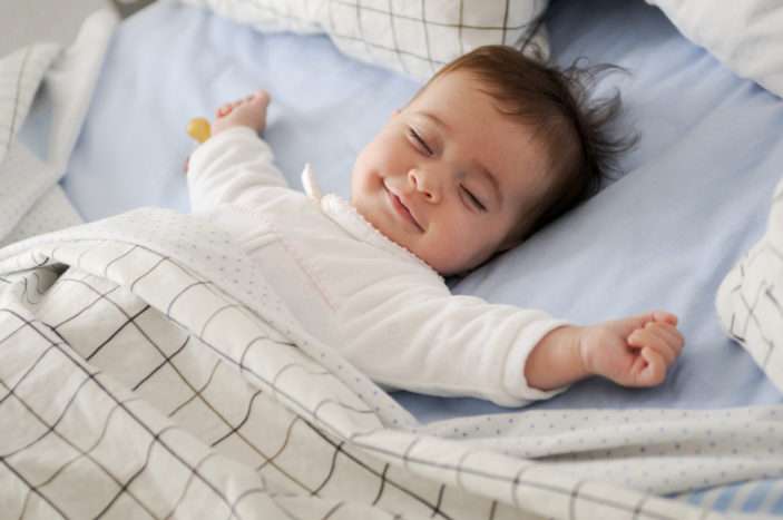 ребенок улыбается во время сна
